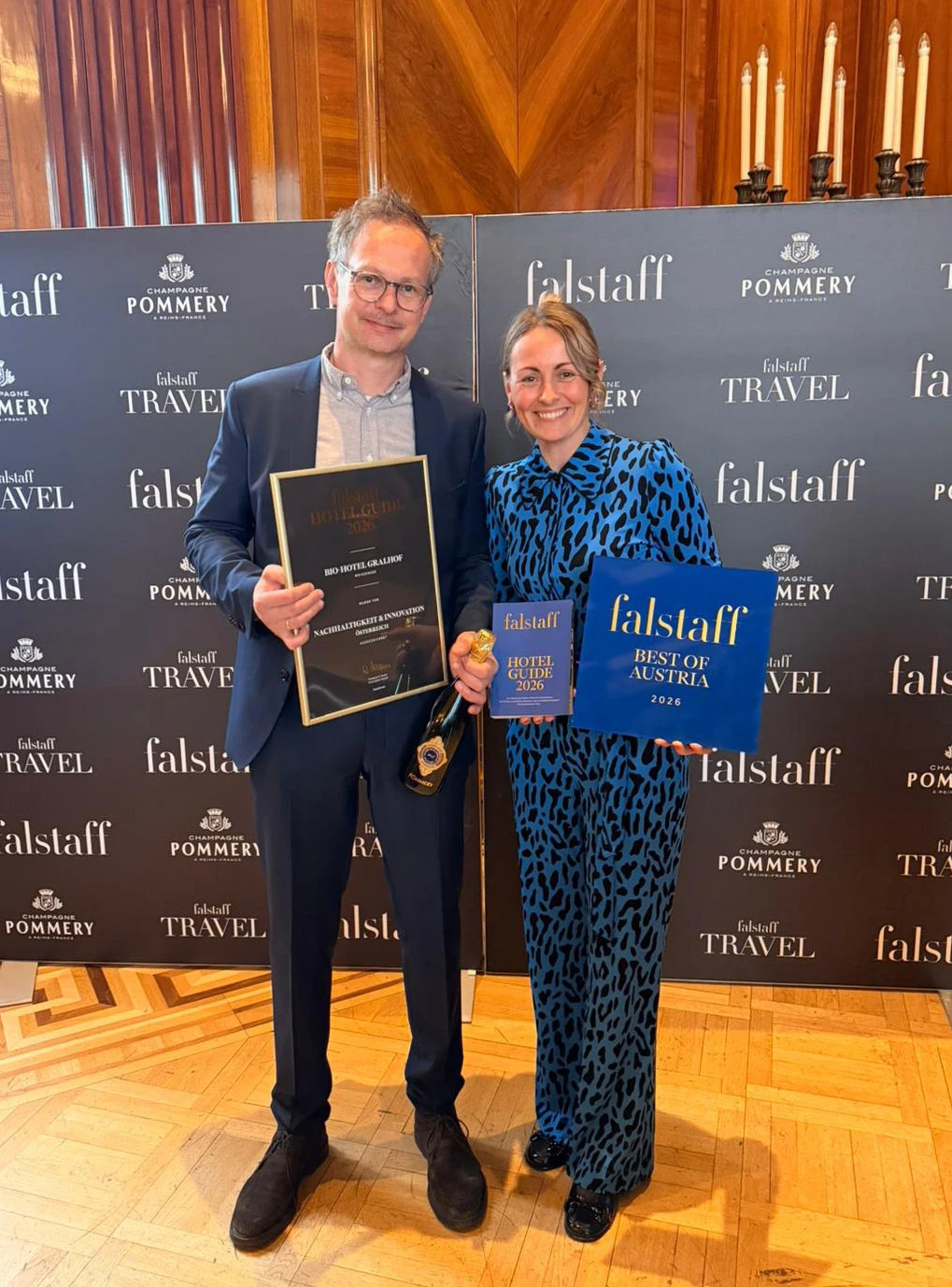 Zwei Personen posieren mit Auszeichnungen bei Falstaff-Veranstaltung; Hintergrund mit Falstaff-Branding und Pommery; blauer Award 'Best of Austria 2026'